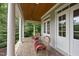 Relaxing front porch features classic columns, brick flooring, and comfortable seating at 1308 Woodgate Manor Ct, Raleigh, NC 27614