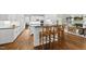 Open gourmet kitchen features white cabinets, black countertops, and island with barstool seating at 1308 Woodgate Manor Ct, Raleigh, NC 27614