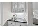 Kitchen area with display cabinets, granite countertops, and a serving area at 1308 Woodgate Manor Ct, Raleigh, NC 27614