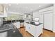 Bright and airy kitchen features white cabinetry, a center island, and stainless steel appliances at 1308 Woodgate Manor Ct, Raleigh, NC 27614