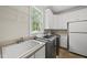Well-lit laundry room with a utility sink, washer, dryer, and plenty of cabinet space at 1308 Woodgate Manor Ct, Raleigh, NC 27614