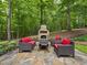 Secluded outdoor stone patio with seating arranged around a charming stone fireplace at 1308 Woodgate Manor Ct, Raleigh, NC 27614