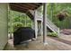 Outdoor patio area with grill, stone flooring, and staircase leading to the upper level of the home at 1308 Woodgate Manor Ct, Raleigh, NC 27614