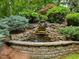 Beautiful tiered stone waterfall surrounded by various plants and greenery, adding tranquility to the landscape at 1308 Woodgate Manor Ct, Raleigh, NC 27614