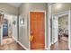 Warm entryway features a bright orange door and hardwood floors at 133 Marino Pl, Clayton, NC 27527