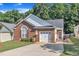Inviting brick home with a paved driveway, attached garage, and a charming red door at 133 Marino Pl, Clayton, NC 27527