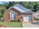 Charming brick home featuring a one-car garage, manicured lawn, and decorative shutters at 133 Marino Pl, Clayton, NC 27527
