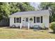 Charming single-story home with a light blue door, brick steps, and a cozy front yard seating area at 1408 Ida St, Durham, NC 27705
