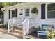 Close up of a charming single-story home with light blue door and cozy front yard seating area at 1408 Ida St, Durham, NC 27705