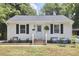 Charming single-story home with a light blue door, brick steps, and a cozy front yard seating area at 1408 Ida St, Durham, NC 27705
