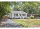 Charming single-story home with a light blue door, brick steps, and a cozy front yard seating area at 1408 Ida St, Durham, NC 27705