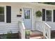 Close up of a charming single-story home with light blue door and cozy front yard seating area at 1408 Ida St, Durham, NC 27705