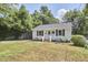 Charming single-story home with a light blue door, brick steps, and a cozy front yard seating area at 1408 Ida St, Durham, NC 27705