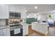 Well-lit kitchen featuring white cabinets, stainless steel appliances, granite counters and an island at 1408 Ida St, Durham, NC 27705