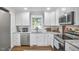 Modern kitchen with white cabinetry, granite countertops, and stainless steel appliances at 1408 Ida St, Durham, NC 27705