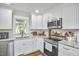 Updated kitchen with stainless appliances, white cabinetry and granite counters at 1408 Ida St, Durham, NC 27705