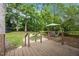 Landscaped backyard with a trampoline, swing set, patio with table, and fire pit area at 1541 Shadylawn Dr, Burlington, NC 27215