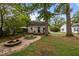 Landscaped backyard with a fire pit, patio area, and lush greenery at 1541 Shadylawn Dr, Burlington, NC 27215