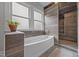 Modern bathroom with a soaking tub, tiled walls, and a separate shower area at 1541 Shadylawn Dr, Burlington, NC 27215