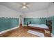 Bedroom with hardwood floors, large windows, and a decoratively painted accent wall at 1541 Shadylawn Dr, Burlington, NC 27215