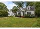 Quaint white home with black shutters, brick steps, and a well-maintained lawn at 1541 Shadylawn Dr, Burlington, NC 27215