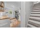 Bright kitchen with wood floors, stainless appliances, white cabinets, and butcher block counters, as viewed from the stairs at 1541 Shadylawn Dr, Burlington, NC 27215