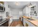 Clean kitchen features white cabinets, butcher block counters, and stainless steel appliances at 1541 Shadylawn Dr, Burlington, NC 27215