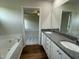 Modern bathroom featuring a bathtub, double sinks, and granite countertops at 180 Tulipfield Way, Benson, NC 27504