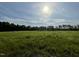 Scenic view of open land under a sky with scattered clouds and a bright sun at 180 Tulipfield Way, Benson, NC 27504
