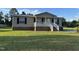 Charming single-story home featuring a cozy front porch and well-maintained lawn on a sunny day at 195 Washington Ln, Cameron, NC 28326
