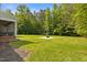 Spacious backyard featuring a fire pit and lush green lawn surrounded by mature trees at 200 Daniel Ridge Ln, Roxboro, NC 27574