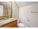 Clean bathroom with a granite countertop vanity, white toilet, and a mirror with wood trim at 200 Daniel Ridge Ln, Roxboro, NC 27574