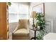 Bright bedroom featuring a neutral armchair next to a decorative table and a large, sunlit window at 200 Daniel Ridge Ln, Roxboro, NC 27574