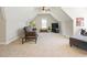 Bonus room featuring a ceiling fan, brown leather seating, a TV, and carpet at 200 Daniel Ridge Ln, Roxboro, NC 27574