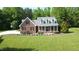 Two-story brick home with manicured lawn and covered front porch creates a welcoming curb appeal at 200 Daniel Ridge Ln, Roxboro, NC 27574