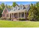 Beautiful brick house featuring a covered porch, dormer windows, and landscaped front yard at 200 Daniel Ridge Ln, Roxboro, NC 27574