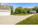 Large garage and long driveway lead to a home with a large lawn and mature trees at 200 Daniel Ridge Ln, Roxboro, NC 27574