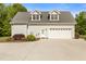 Large garage with a concrete driveway and neutral-colored exterior, with lush landscaping at 200 Daniel Ridge Ln, Roxboro, NC 27574