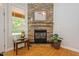 Cozy fireplace with stone surround, hardwood floors, and a large window at 200 Daniel Ridge Ln, Roxboro, NC 27574