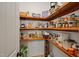 Organized pantry with wooden shelves holding a variety of food items and a wine rack at 200 Daniel Ridge Ln, Roxboro, NC 27574