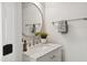 Elegant bathroom vanity with a marble countertop, round mirror, and modern fixtures at 2004 Tennessee Rd, Durham, NC 27704