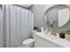 Updated bathroom features a round mirror, updated lighting and fixtures, and vanity storage at 2004 Tennessee Rd, Durham, NC 27704