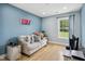Comfortable bedroom featuring wood floors, a window, and a calming blue accent wall at 2004 Tennessee Rd, Durham, NC 27704