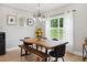 Modern dining room with a large wood table, contemporary lighting, and large windows offering a view at 2004 Tennessee Rd, Durham, NC 27704
