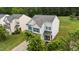 Inviting two-story home showcasing gray siding, blue shutters, well-manicured lawn, and lush trees at 2004 Tennessee Rd, Durham, NC 27704