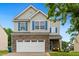 Charming two-story home featuring stone accents, blue shutters, and an attached two-car garage at 2004 Tennessee Rd, Durham, NC 27704