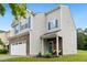 Charming two-story home with a stone facade, blue door, shutters, manicured landscaping, and a two-car garage at 2004 Tennessee Rd, Durham, NC 27704