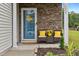 Inviting front porch with a blue door, chairs with yellow cushions, and decorative plants at 2004 Tennessee Rd, Durham, NC 27704