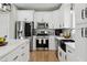 Modern kitchen with stainless appliances, white cabinets, marble counters, and a farmhouse sink at 2004 Tennessee Rd, Durham, NC 27704