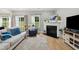 Comfortable living room with a fireplace, large windows, hardwood floors, and a cozy seating area at 2004 Tennessee Rd, Durham, NC 27704